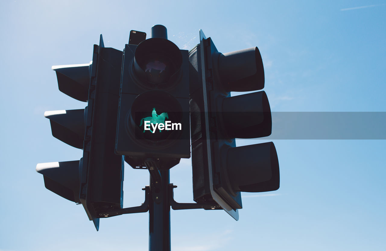 Low angle view of road sign against clear blue sky