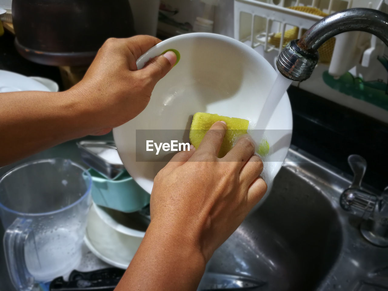 Person washing dishes in sink