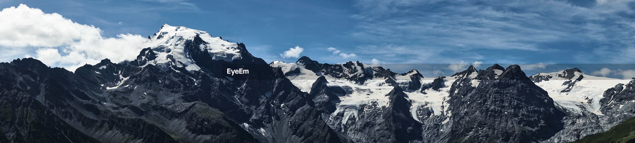 PANORAMIC VIEW OF MOUNTAIN RANGE AGAINST SKY