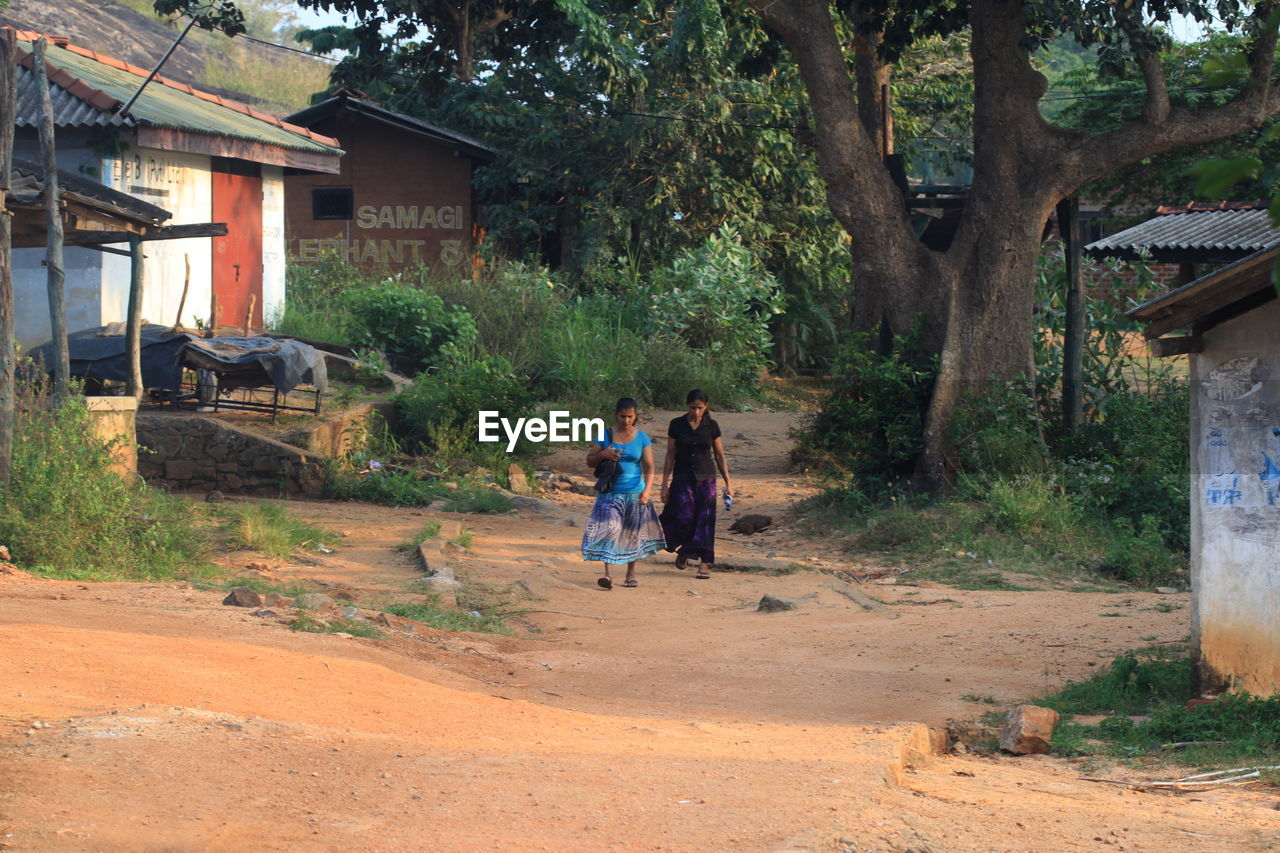 Two women walking on country road