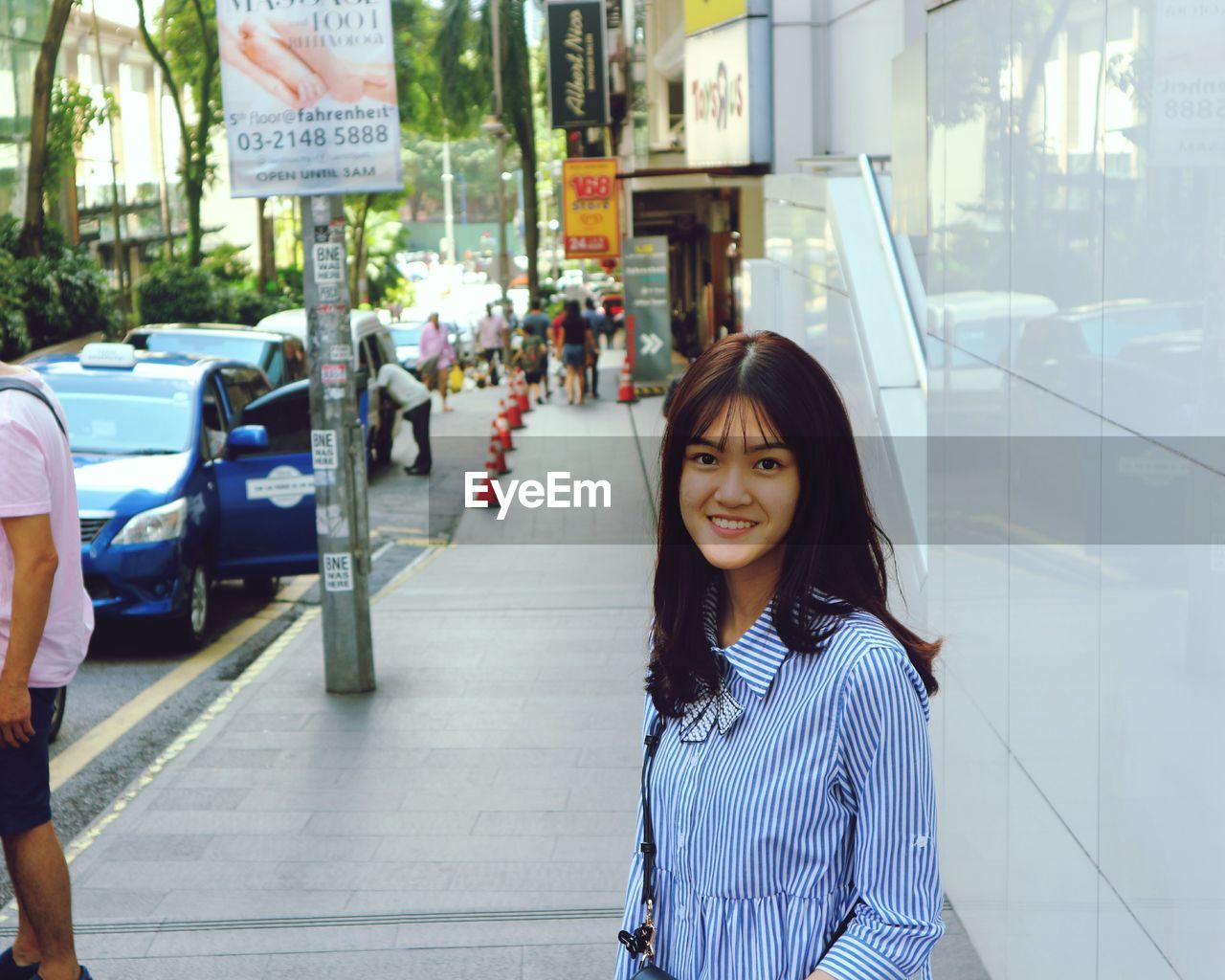 Portrait of woman standing in city