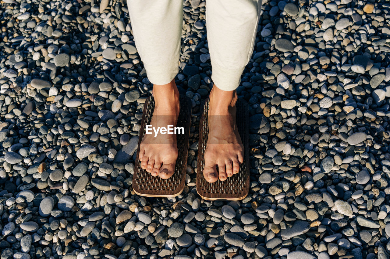 Close-up of female feet on boards with nails practice acupressure.