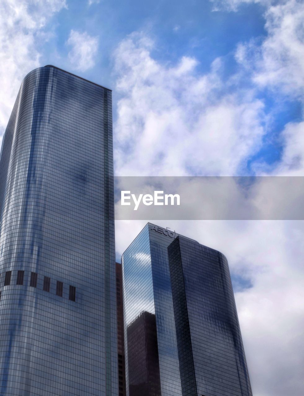 Low angle view of modern building against cloudy sky