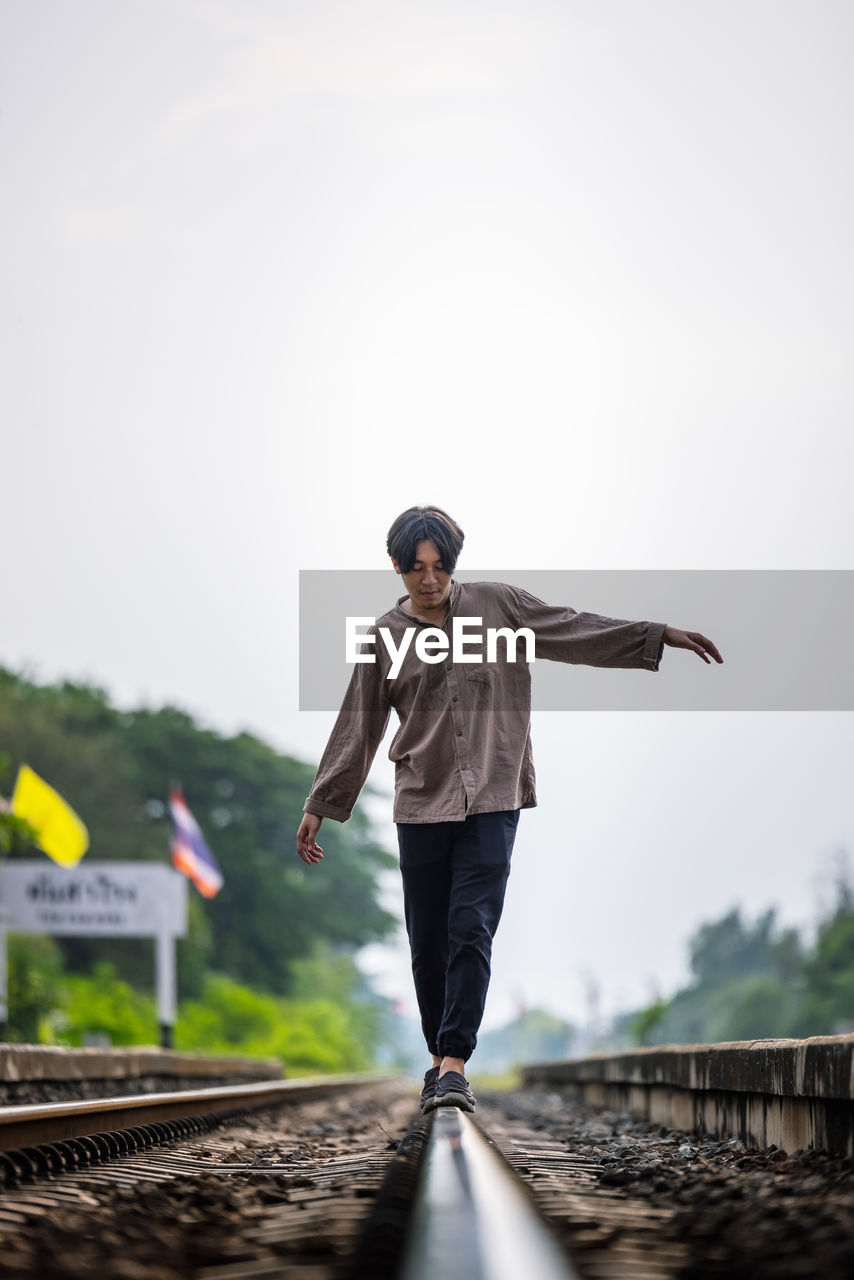 Man walk away on railroad with warm light. selective focus. traveler man on railroad. person