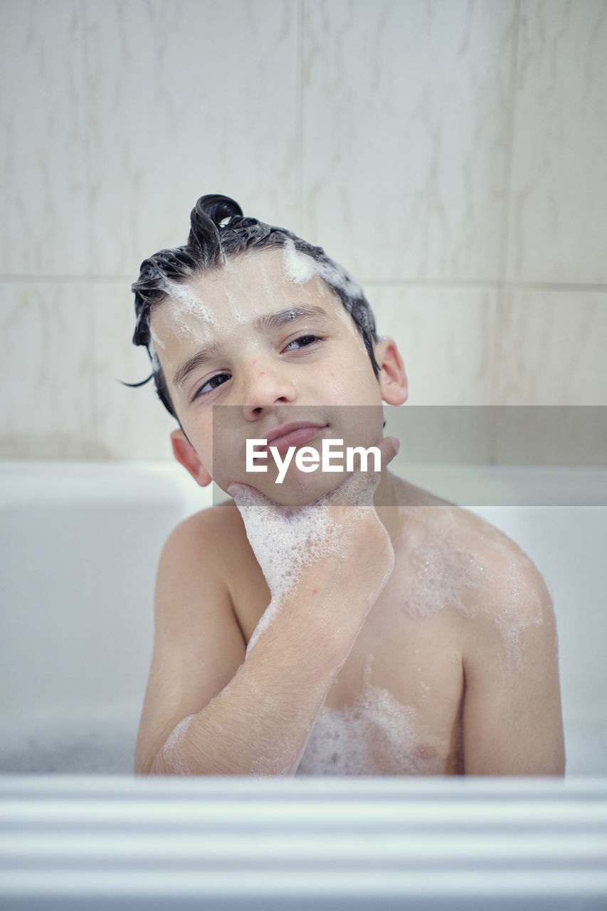 Brothers bathing and playing with foam