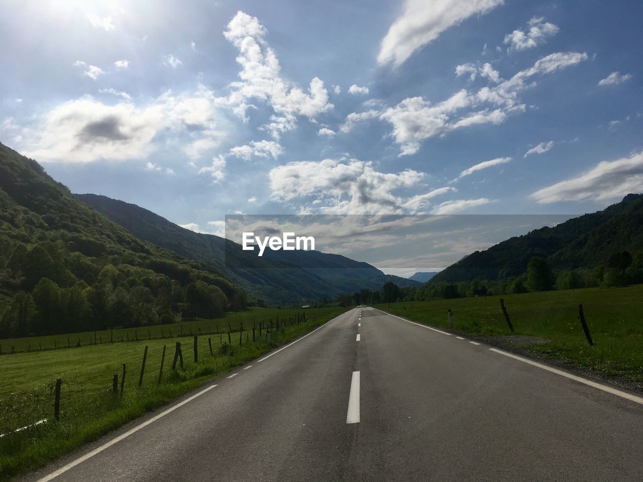 EMPTY ROAD ALONG COUNTRYSIDE LANDSCAPE