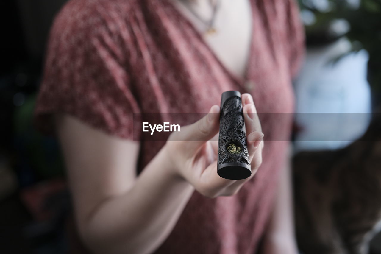 MIDSECTION OF WOMAN USING MOBILE PHONE