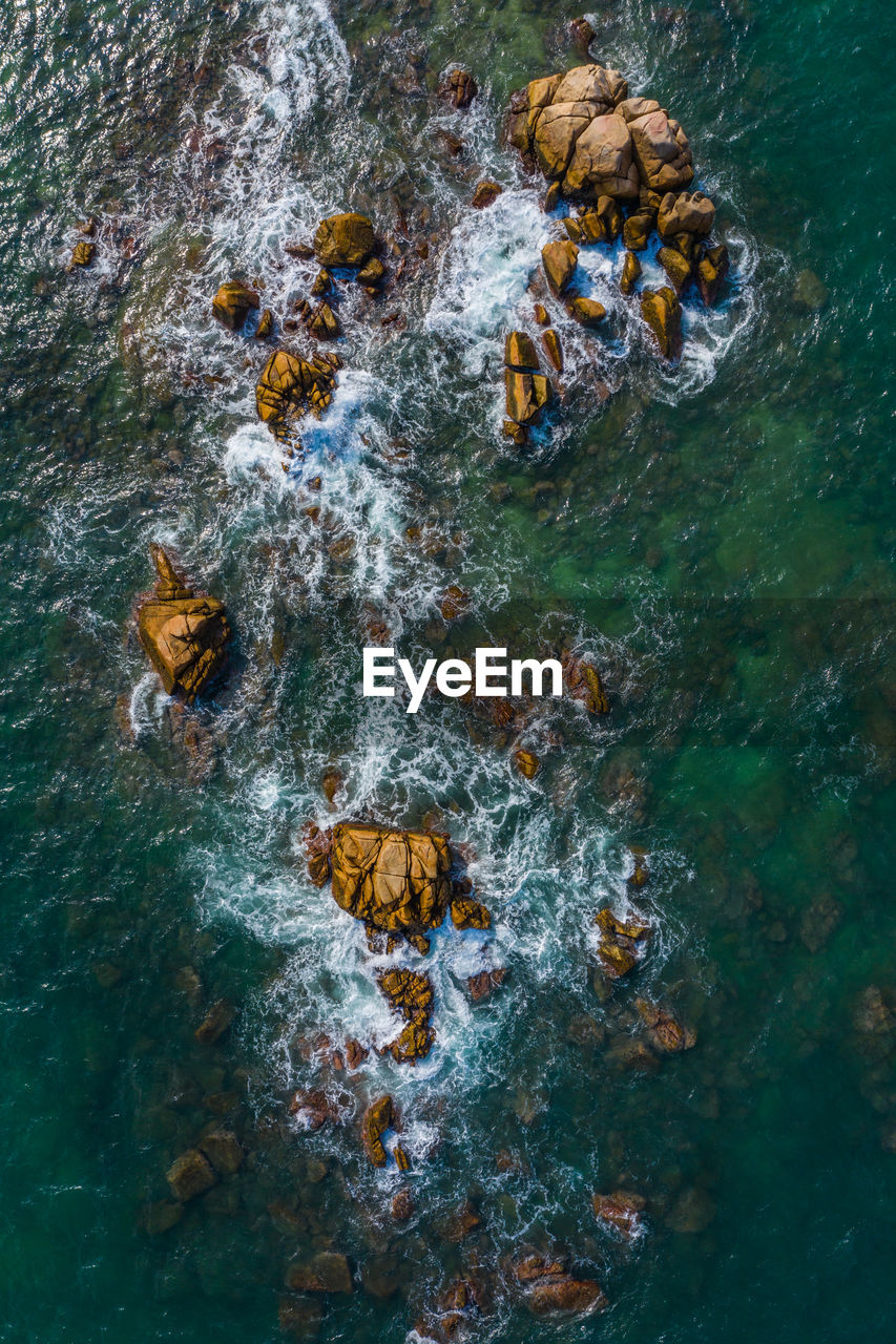 Aerial view of rocks in sea