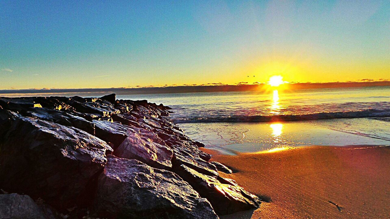 Scenic view of sea against clear sky at sunset