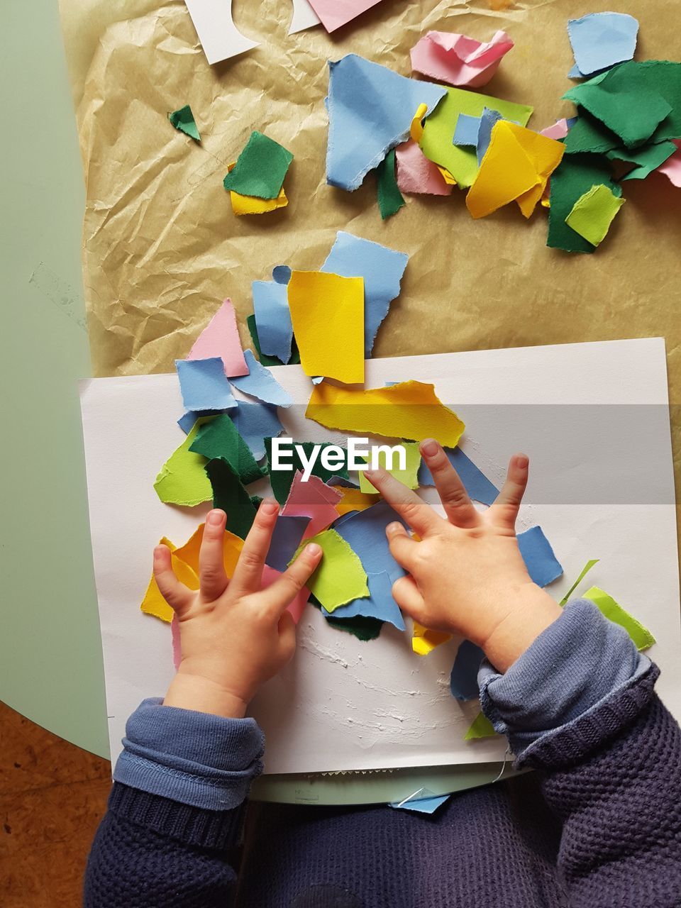 High angle view of child hand holding paper