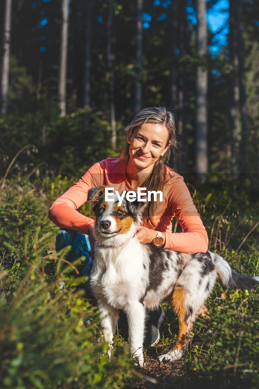 Candid portrait of female athlete with her running and hiking partner, an australian shepherd dog