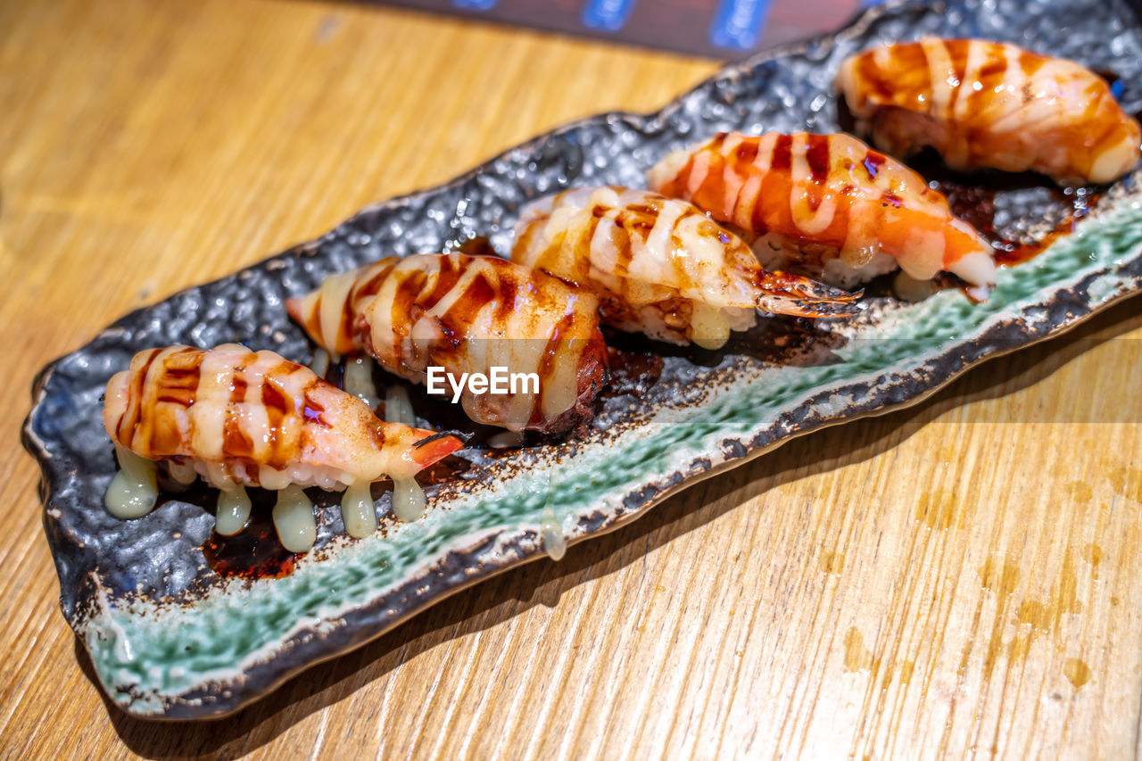 There is a delicious plate of japanese sushi on the table