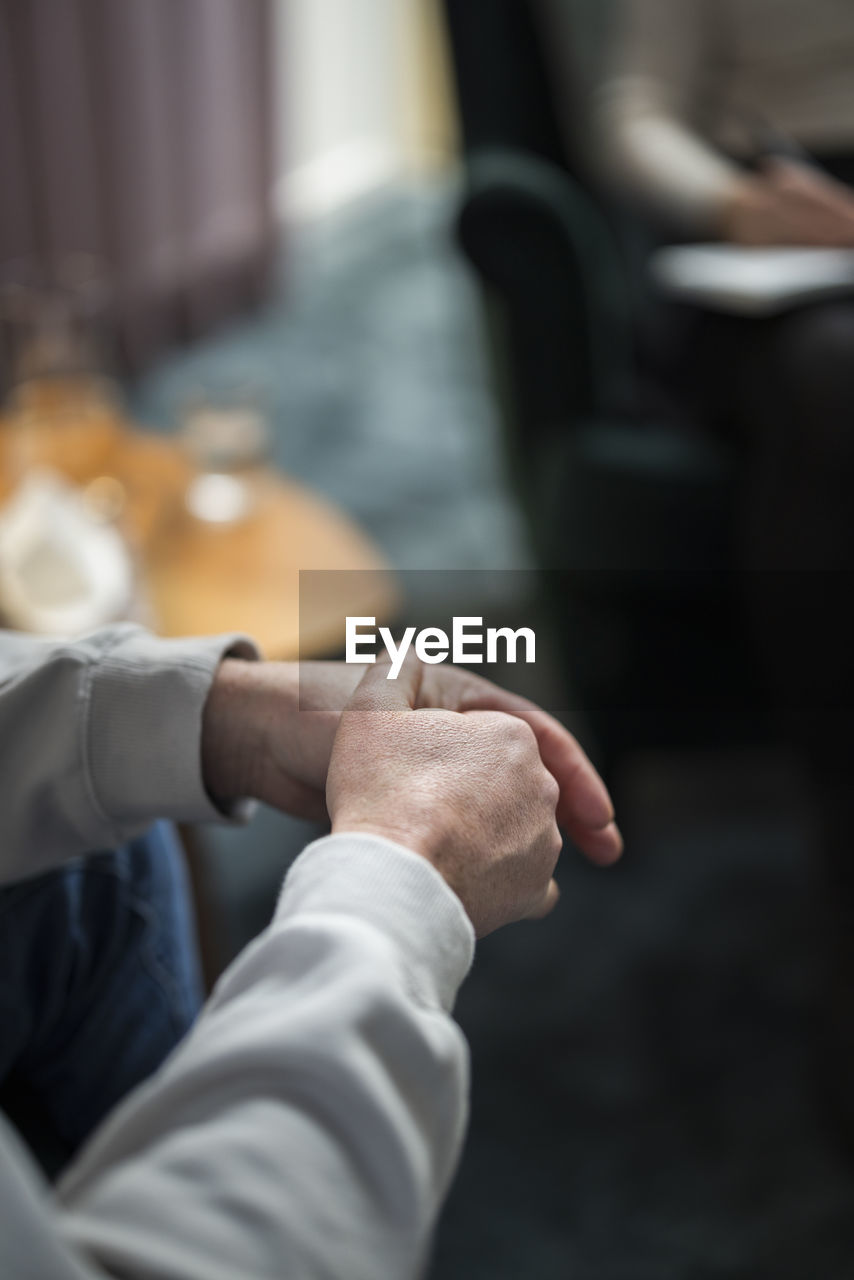 Man wringing hands at therapy session