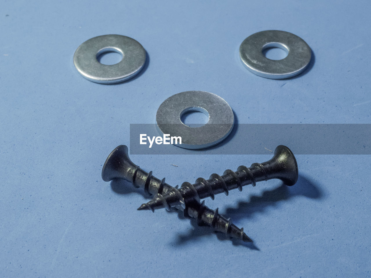 High angle view of screws on blue background