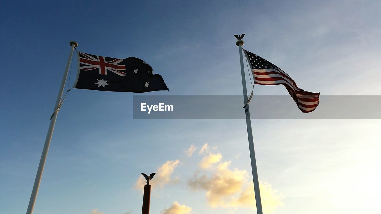 Low angle view of flags against blue sky