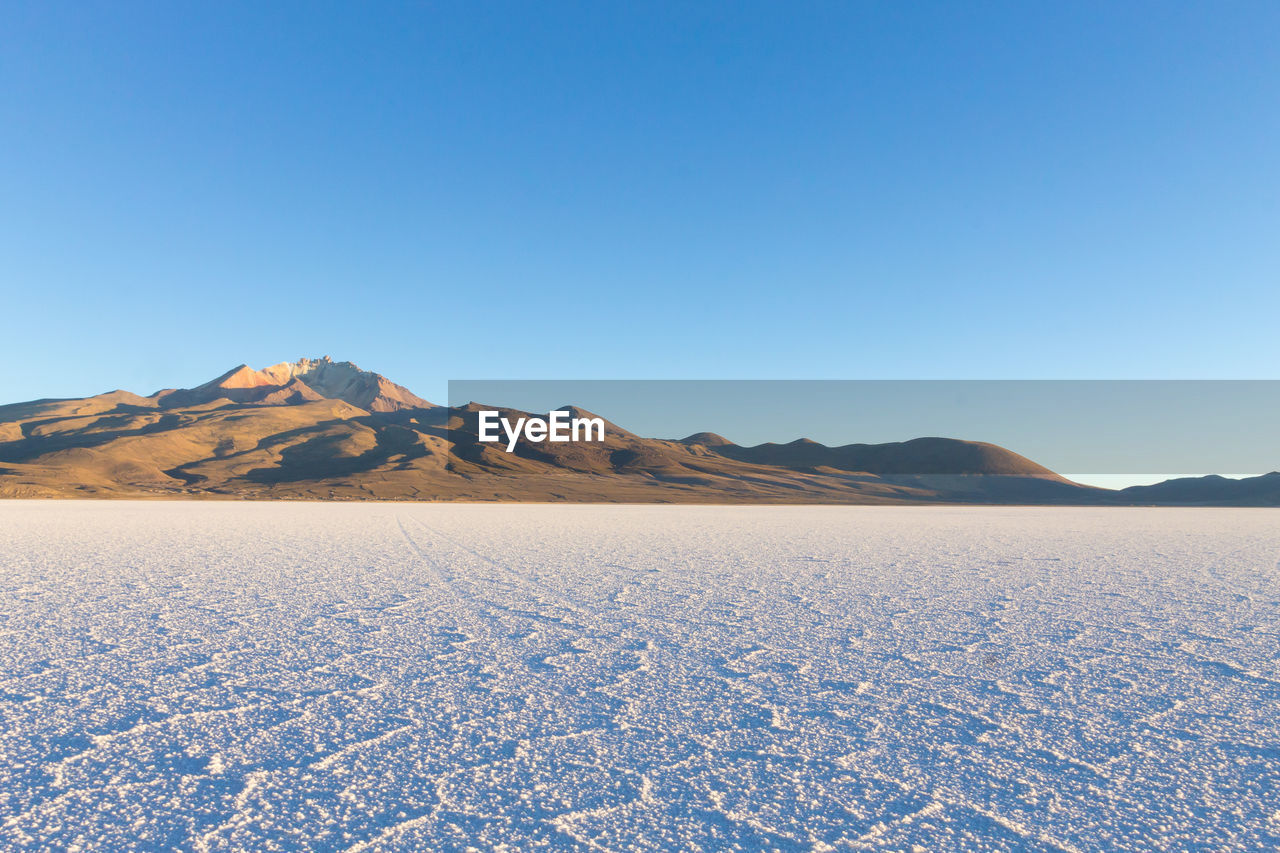 Scenic view of mountains against clear blue sky