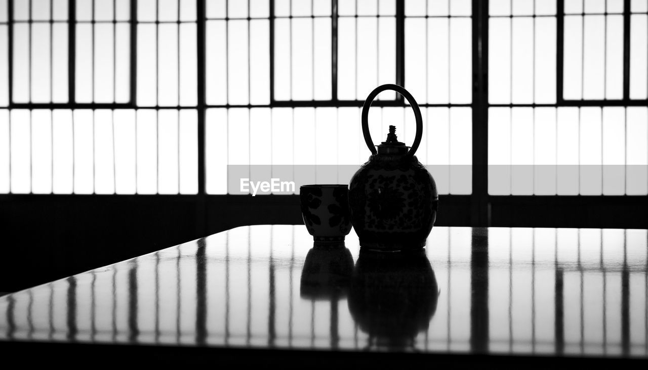 Silhouette of a japanese tea cup and tea kettle in a japanese house.