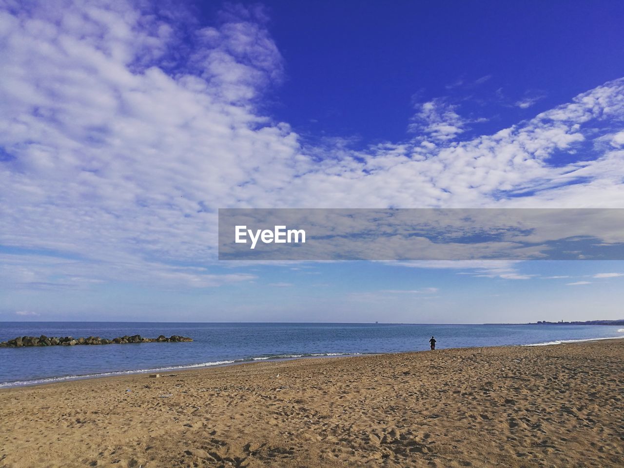 VIEW OF CALM BEACH AGAINST THE SKY