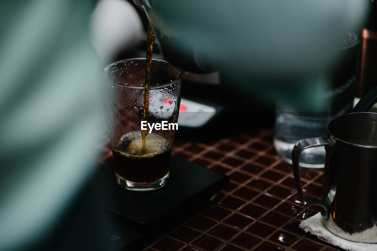 Drink pouring in glass on table