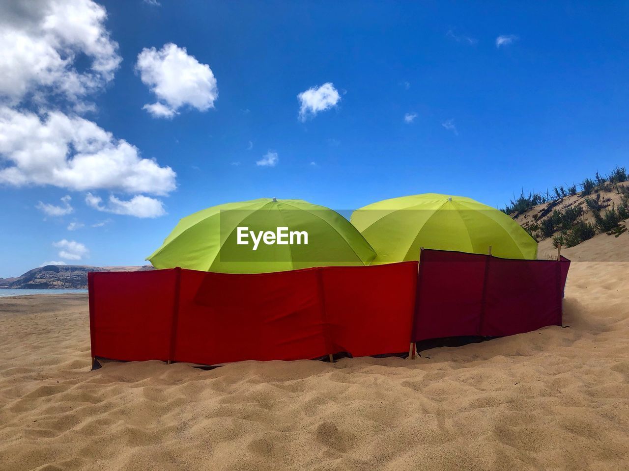 Umbrella on beach against blue sky