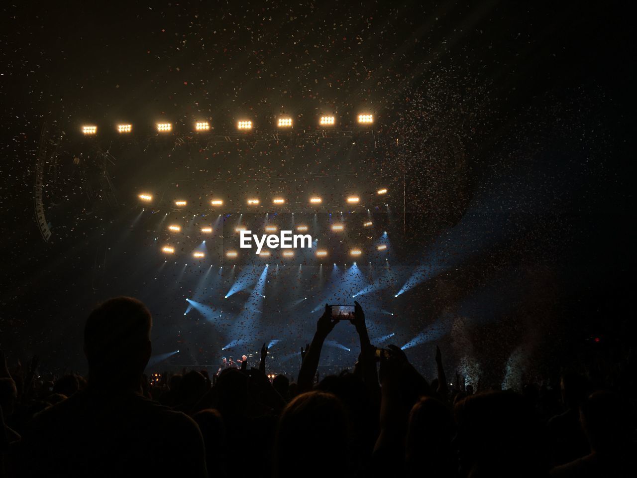 Crowd at music concert against sky at night