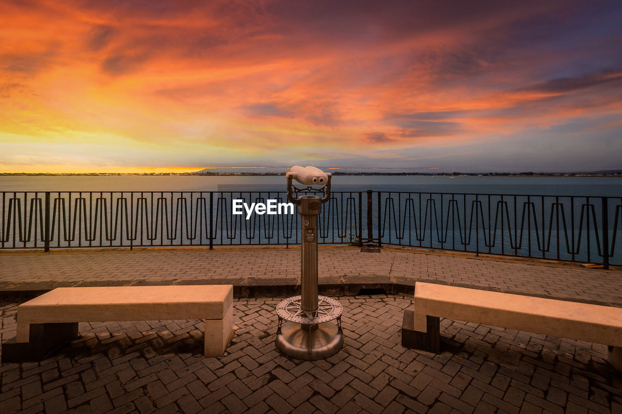 Sunset over the sea with panoramic binoculars in the foreground