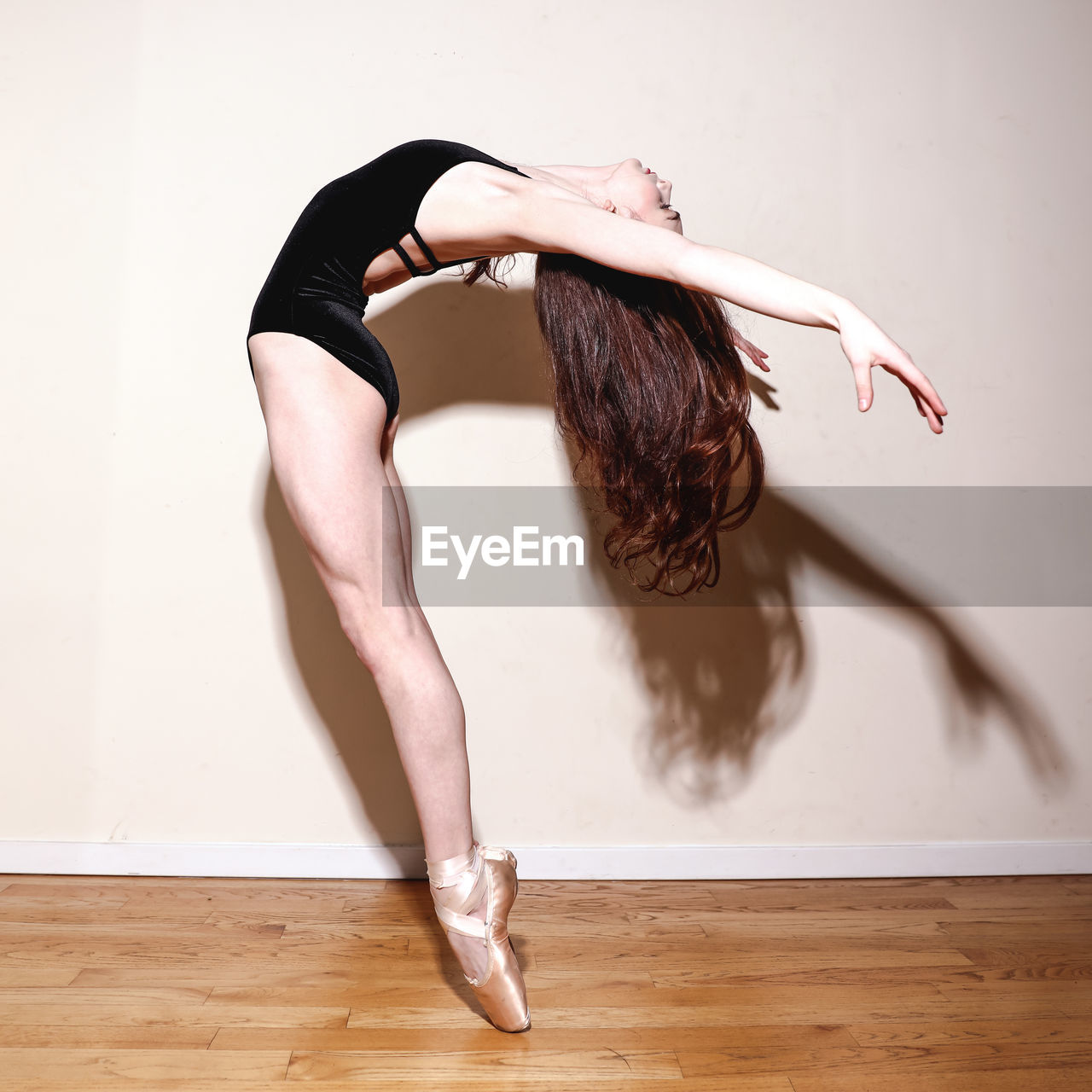 MIDSECTION OF WOMAN WITH ARMS RAISED ON FLOORING