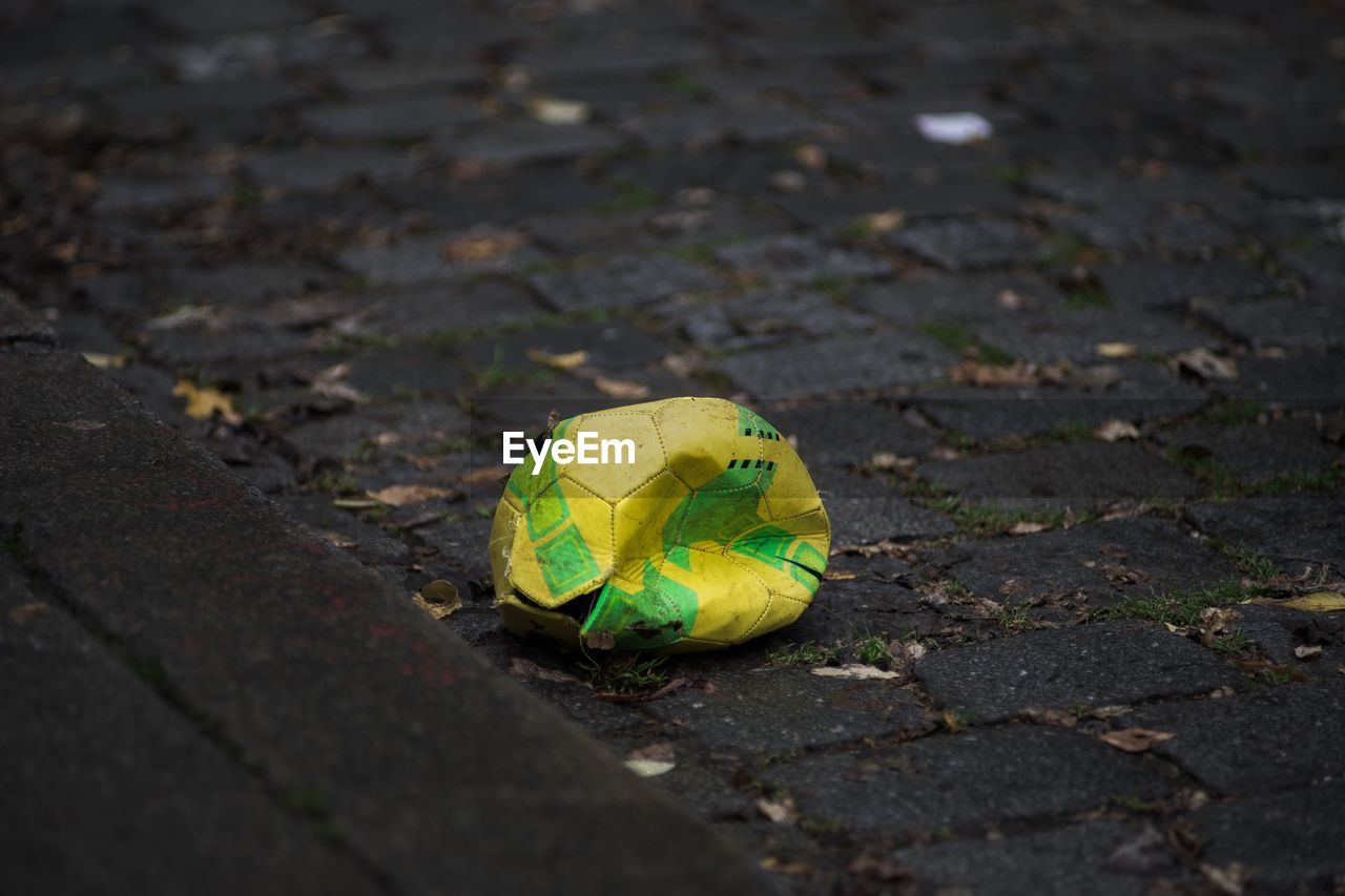 Deflated soccer ball on sidewalk