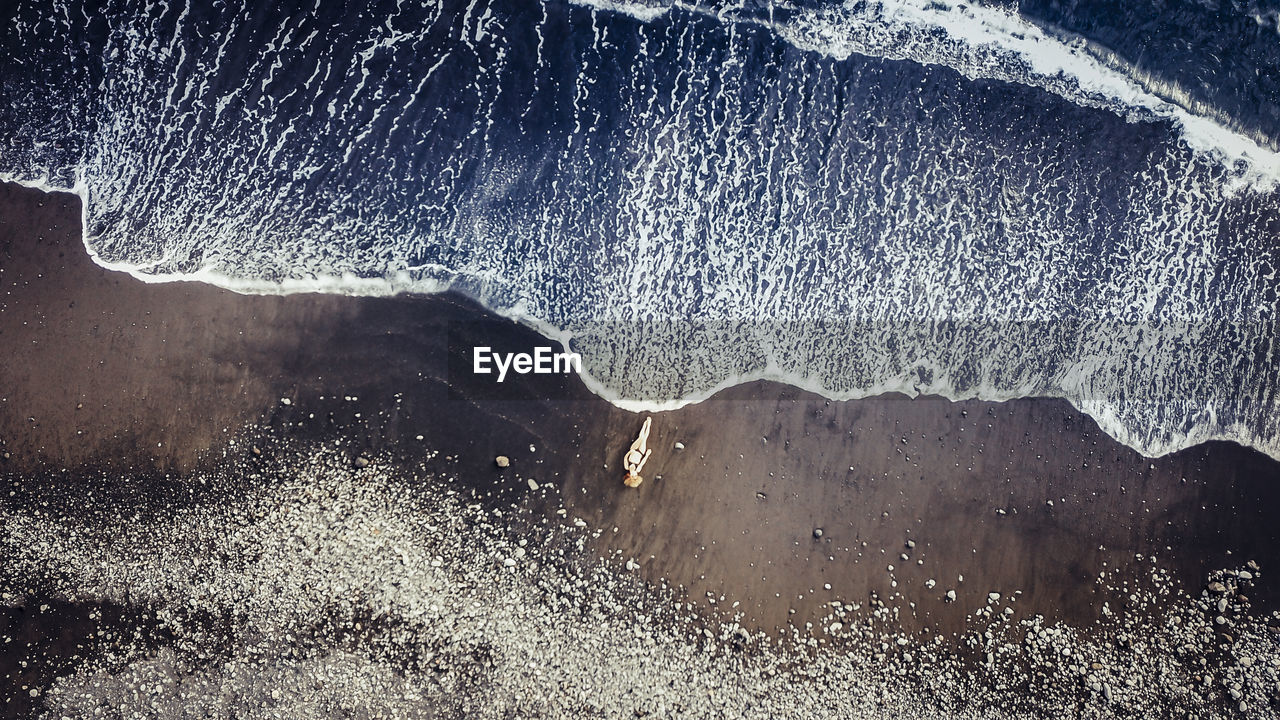 High angle view of woman lying at beach