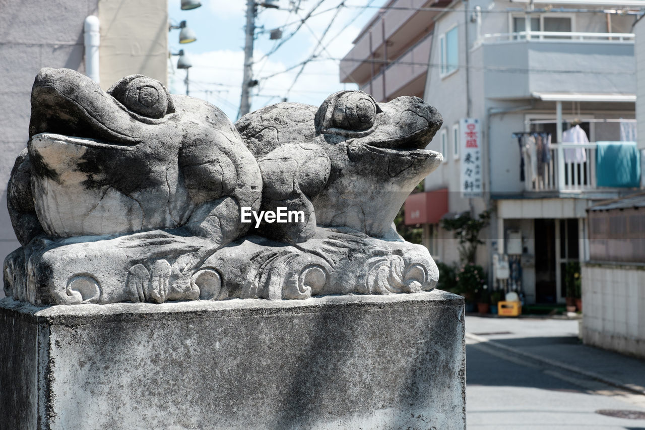 CLOSE-UP OF STATUE IN CITY