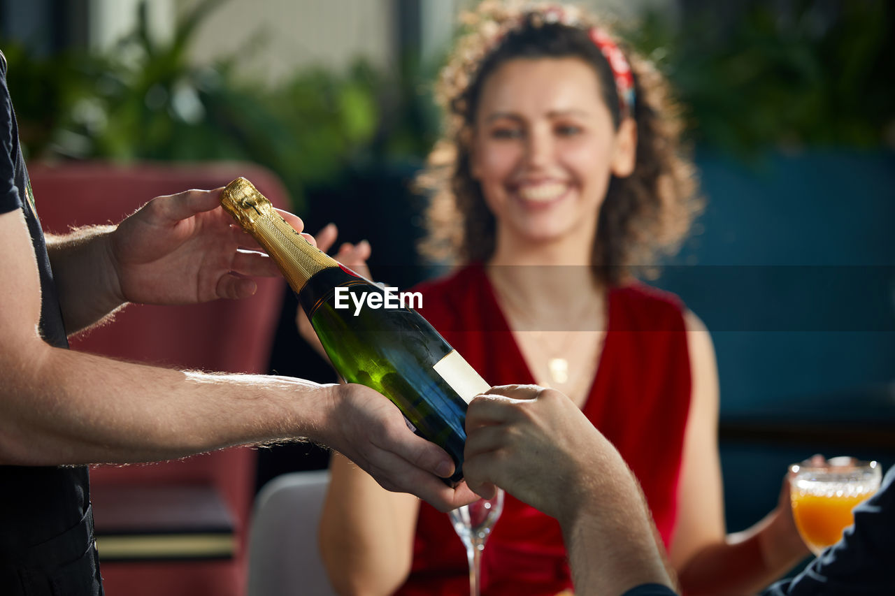 WOMAN HOLDING DRINK WITH BOTTLE OF WINE