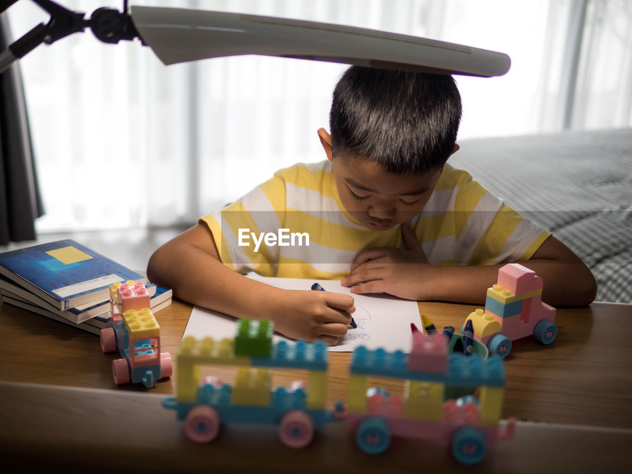 High angle view of boy coloring at table