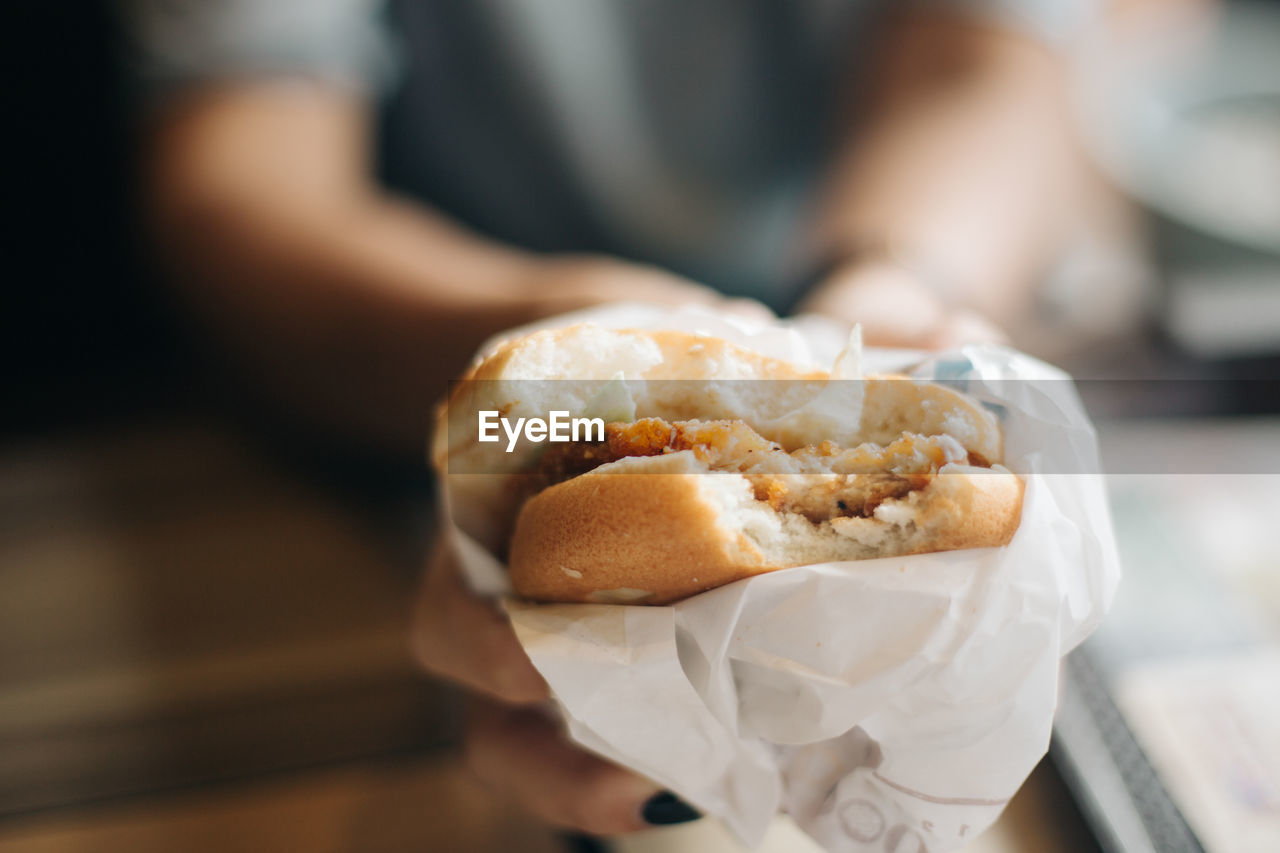 Midsection of woman holding burger