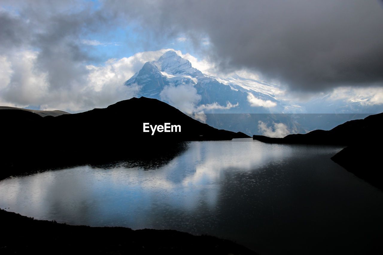 Scenic view of mountains against cloudy sky