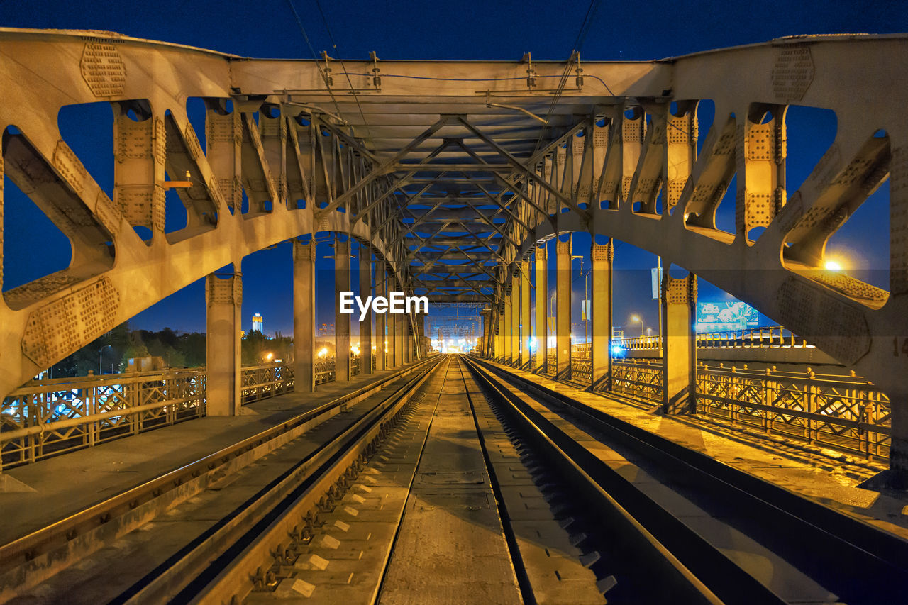 Railway bridge against sky at night