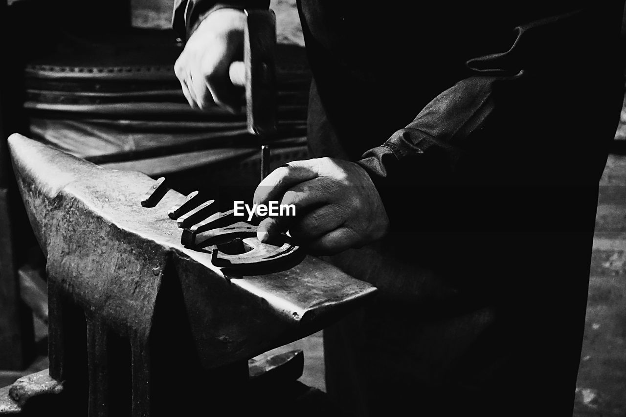 CLOSE-UP OF MAN WORKING ON METAL