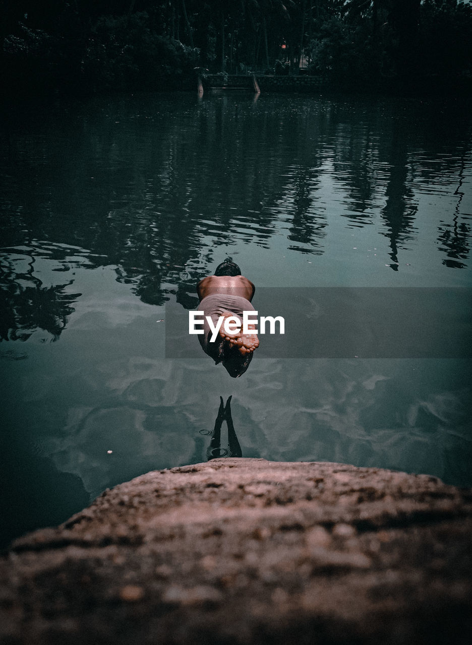 Rear view of man swimming in lake