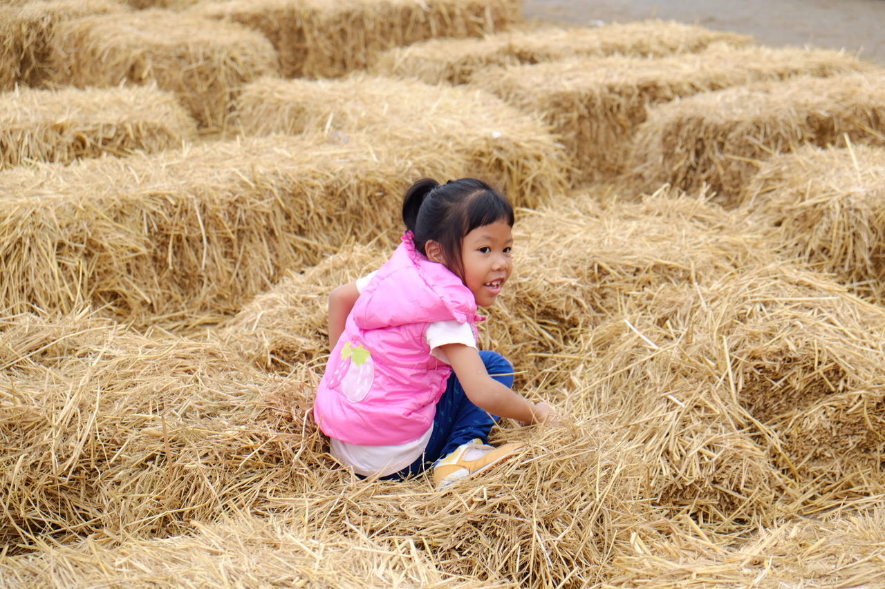 Girl sitting on hay