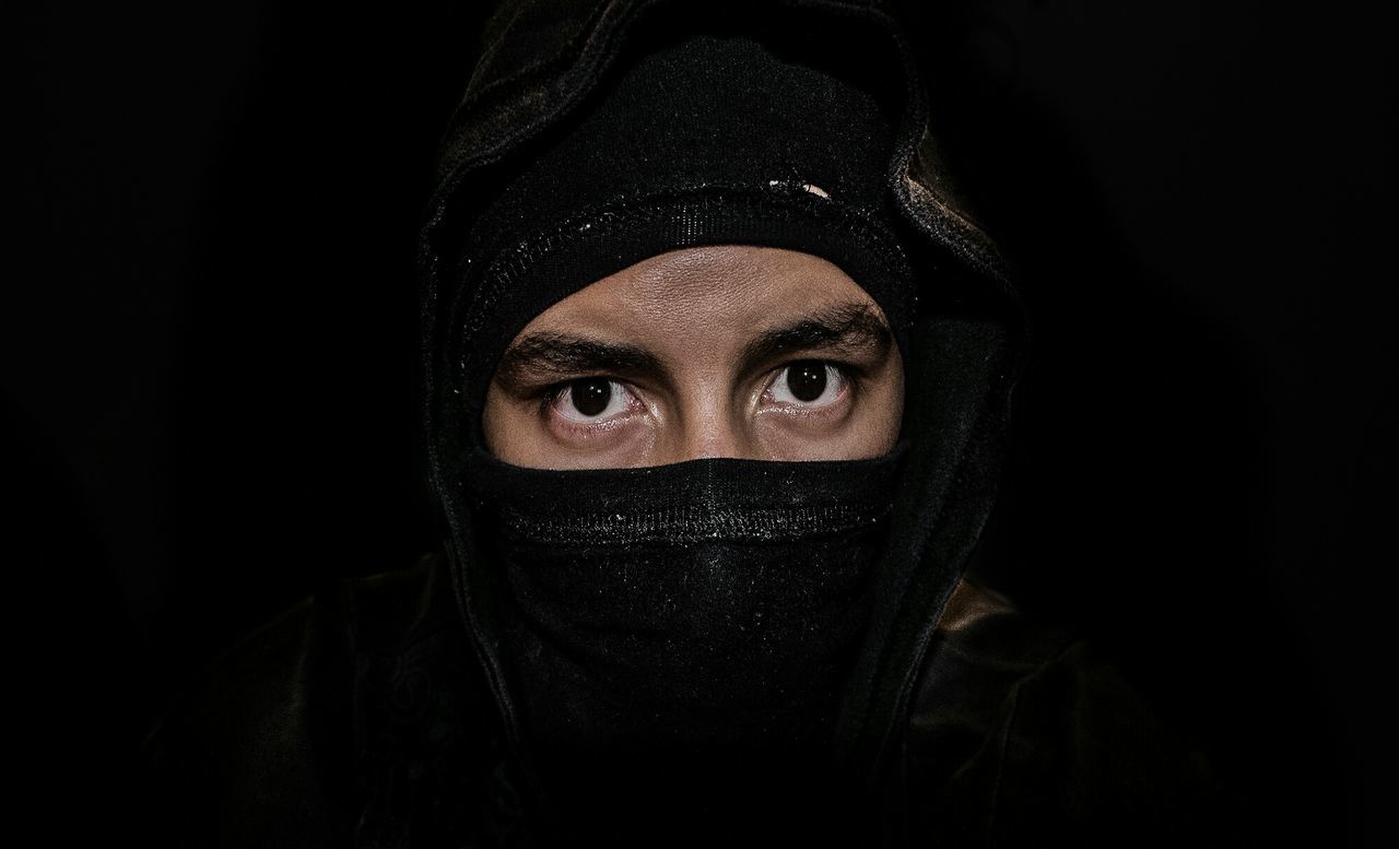 Portrait of man with headscarf against black background