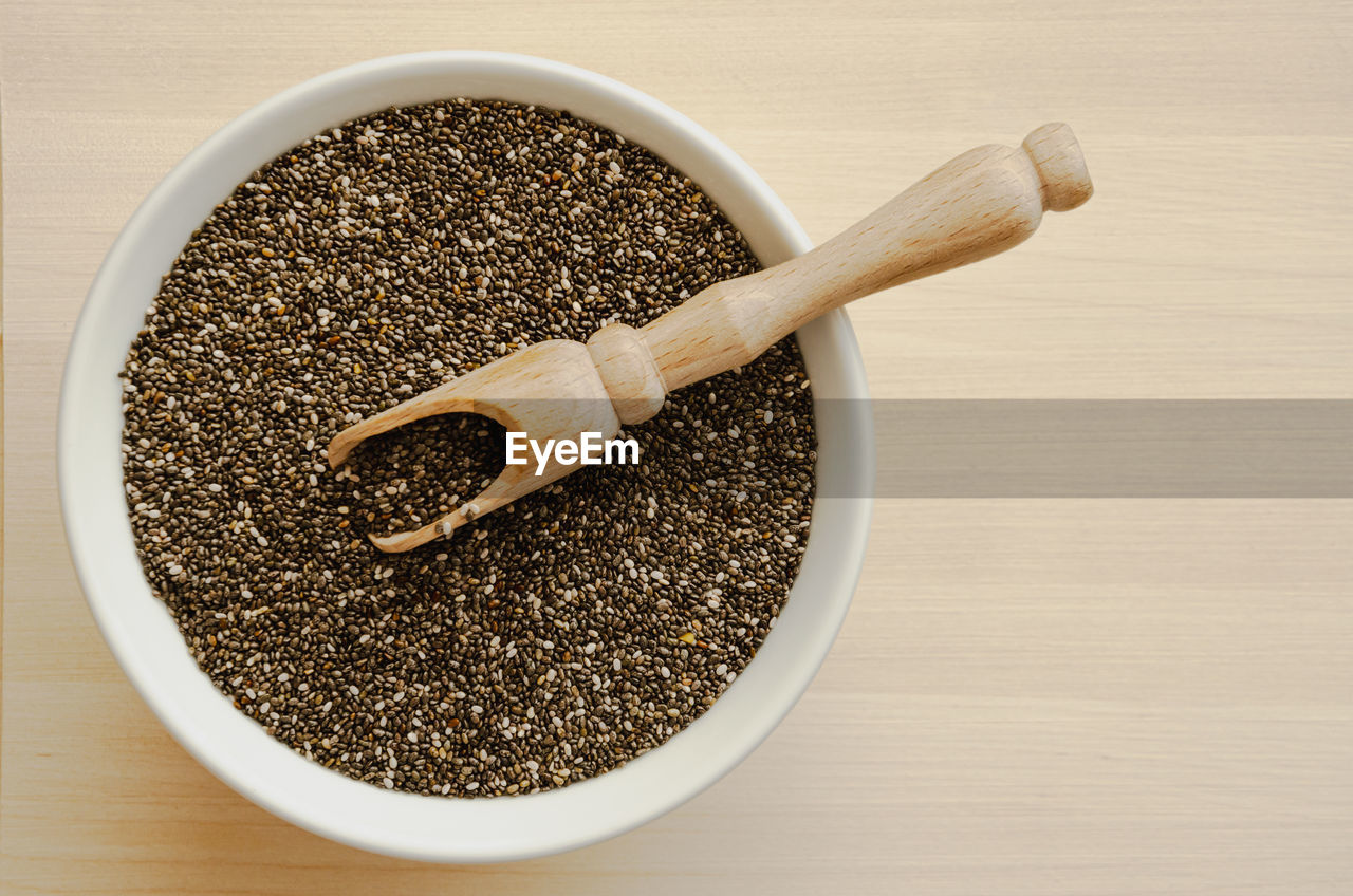 Chia seeds in a plate with a wooden spoon for healthy nutrition