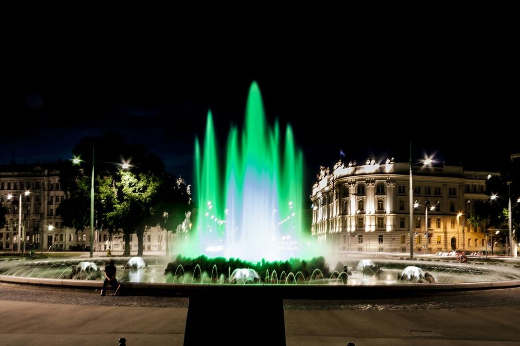 Green fountain in city at night