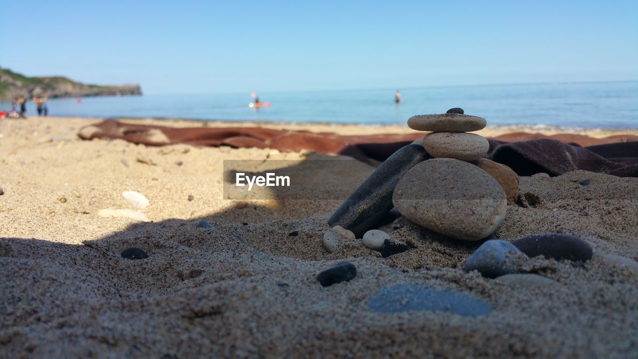 Close-up of pebbles on beach against sky