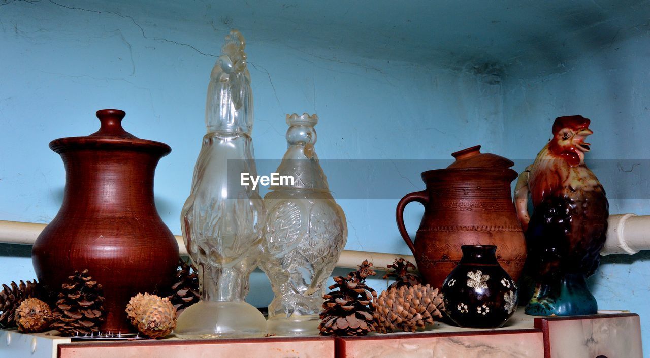 Close-up of glass jar on table against wall