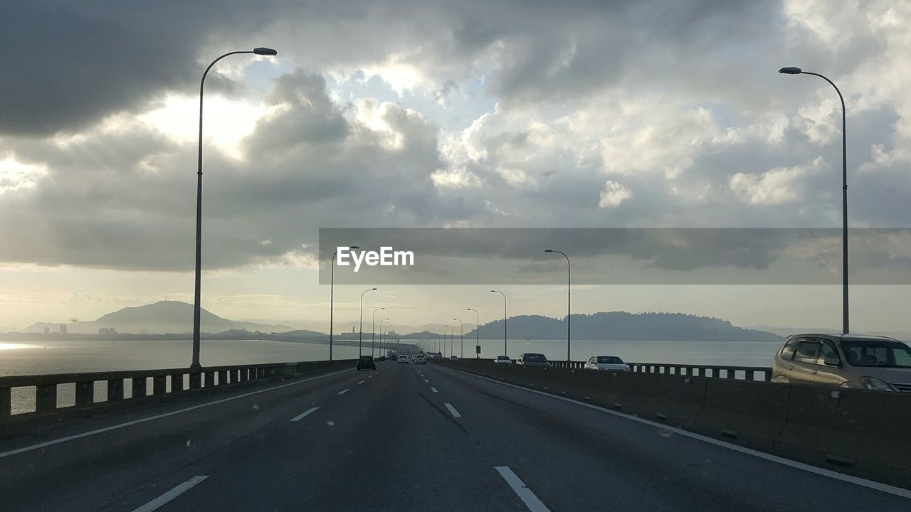 Empty road against cloudy sky