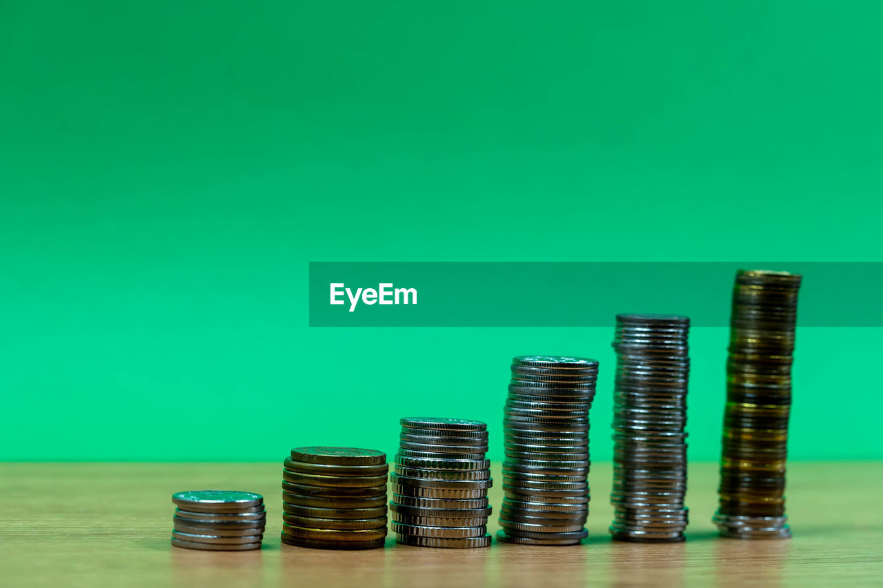 STACK OF COINS ON TABLE AGAINST BLUE BACKGROUND