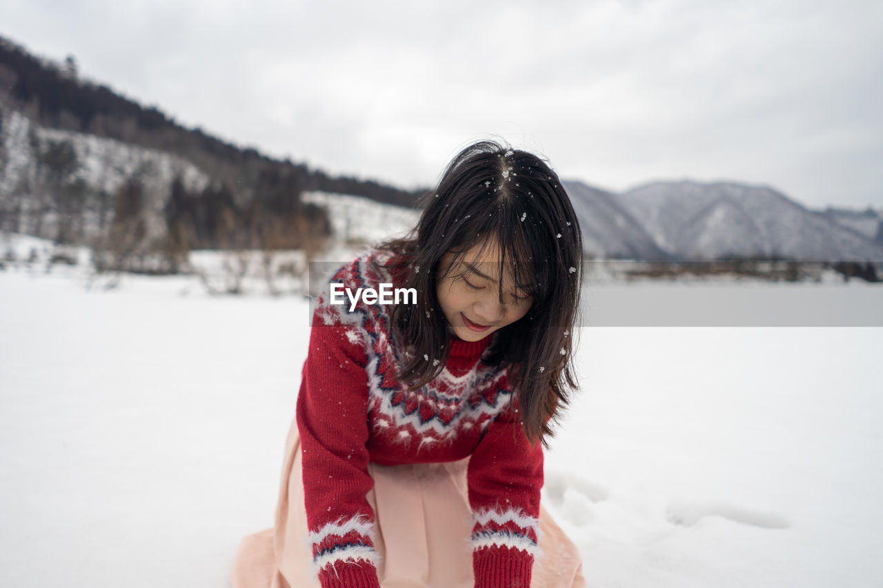 Woman playing with snow during winter