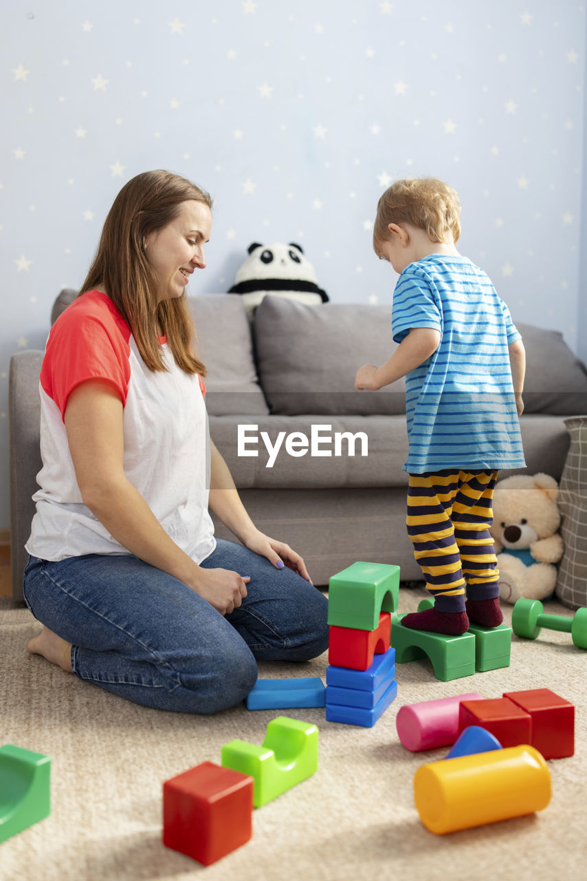 side view of mother and daughter sitting on table