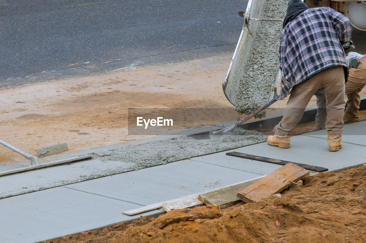 one person, roof, working, men, floor, asphalt, occupation, sand, manual worker, adult, day, water, construction industry, road surface, wood, casual clothing, construction site, flooring, construction, lifestyles, nature, full length, low section, outdoors, walkway, construction worker, industry, wall, standing, walking, road, clothing, hat