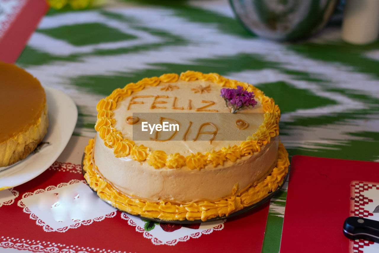 HIGH ANGLE VIEW OF CAKE ON TABLE AGAINST WALL