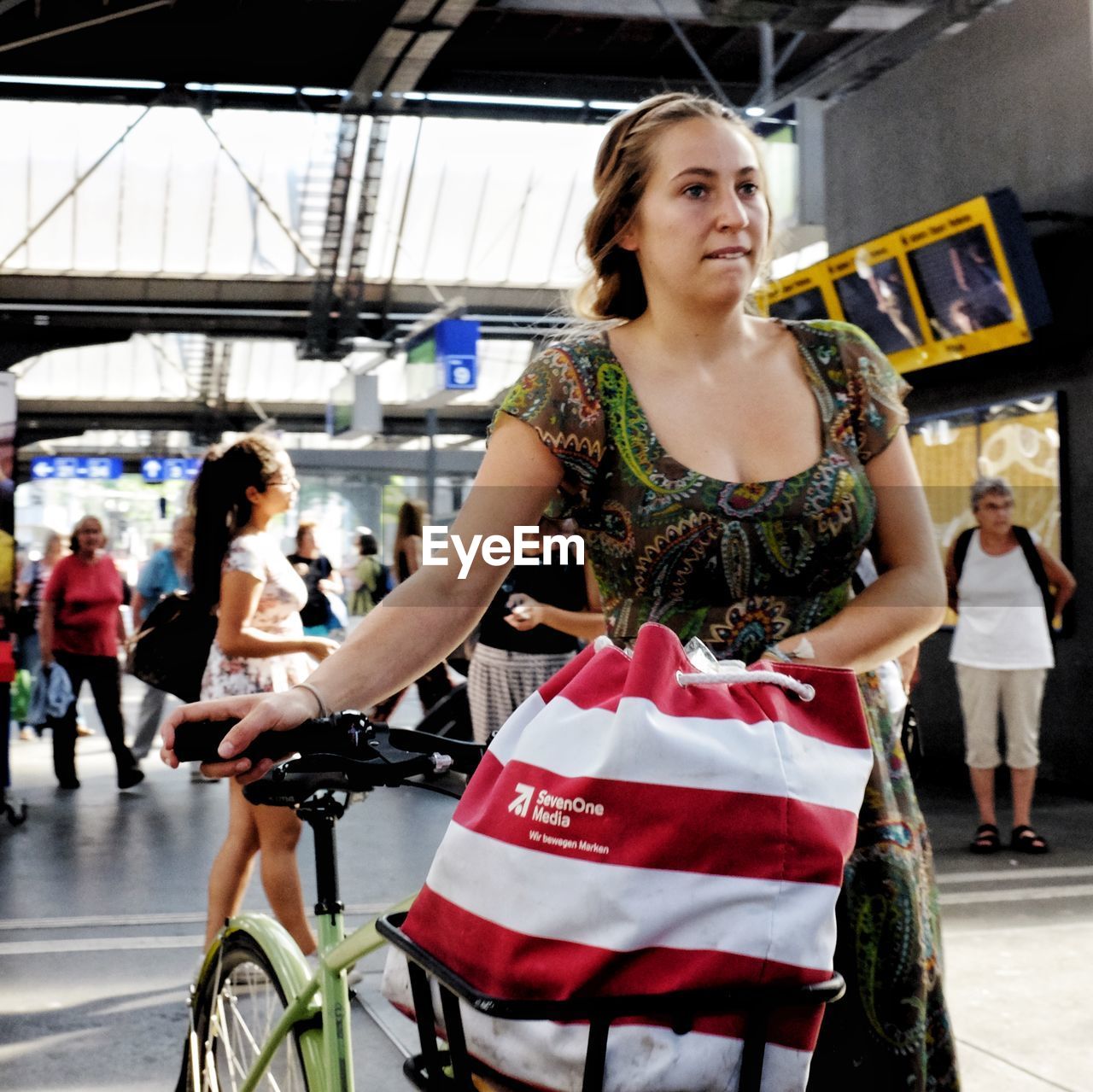 YOUNG WOMAN SITTING IN CITY